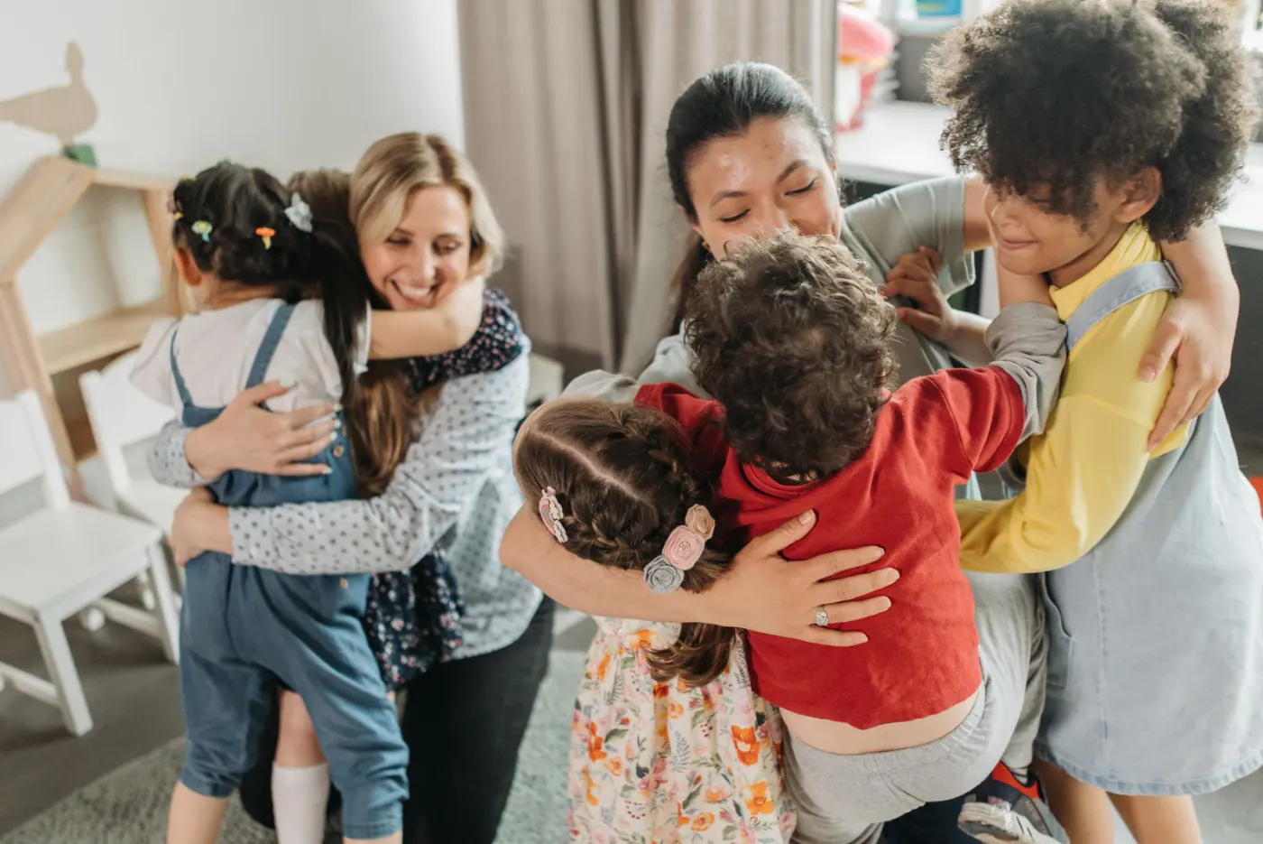 Kinderen en begeleiders in een groepsknuffel